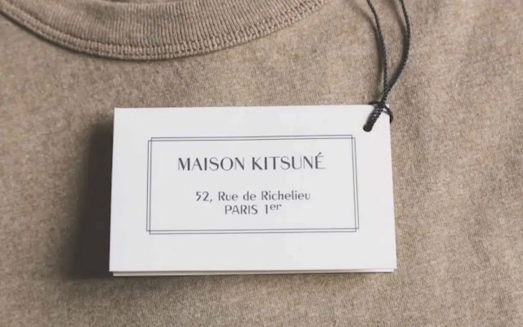 Vemos un tipo de naming de marca con una imagen de una etiqueta con el nombre de una marca en francés sobre una prenda de ropa