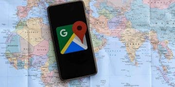 Vemos por qué no aparece mi negocio en google maps con una imagen de un celular con la app google maps sobre un mapa mundial de papel.