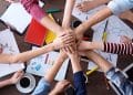 vemos qué es un emprendedor social con una imagen de muchas manos unidas en un proyecto en común.