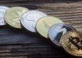 En la imagen se ve una representación de distitnas criptomonedas sobre una mesa de madera para ejemplificar sobre el futuro de solana, ethereum y otras cyptos, en base a las declaraciones de Vitalik Buterin