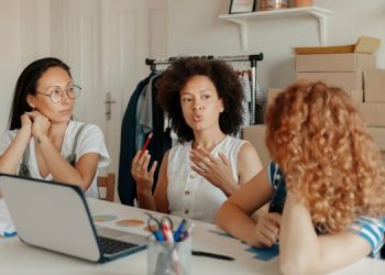 Vemos una imagen de tres mujeres trabajando en una microempresa con una computadora.
