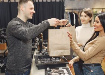 Persona entregando un paquete a una clienta.