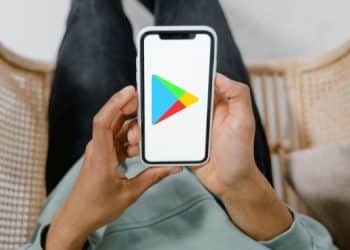 Persona sosteniendo celular con ícono de Play Store