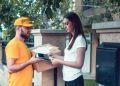 En la imagen se ve a un repartidor realizando un pago contra entrega a un cliente.