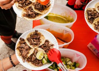 Vemos una imagen de personas consumiendo tacos en un pequeño negocio, en relación con ideas de nombres para taquerías.