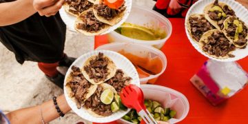 Vemos una imagen de personas consumiendo tacos en un pequeño negocio, en relación con ideas de nombres para taquerías.