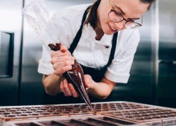 Vemos una imagen de una persona trabajando chocolate, en relación con el diseño de un estudio de mercado de una empresa de chocolates.