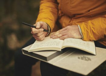 una mujer escribe en un cuaderno haciendo la práctica del journaling