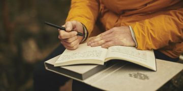 una mujer escribe en un cuaderno haciendo la práctica del journaling