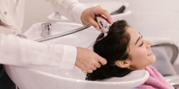 Vemos una imagen de una mujer lavando el cabello de otra persona, en referencia a la búsqueda de nombres para salón de belleza.