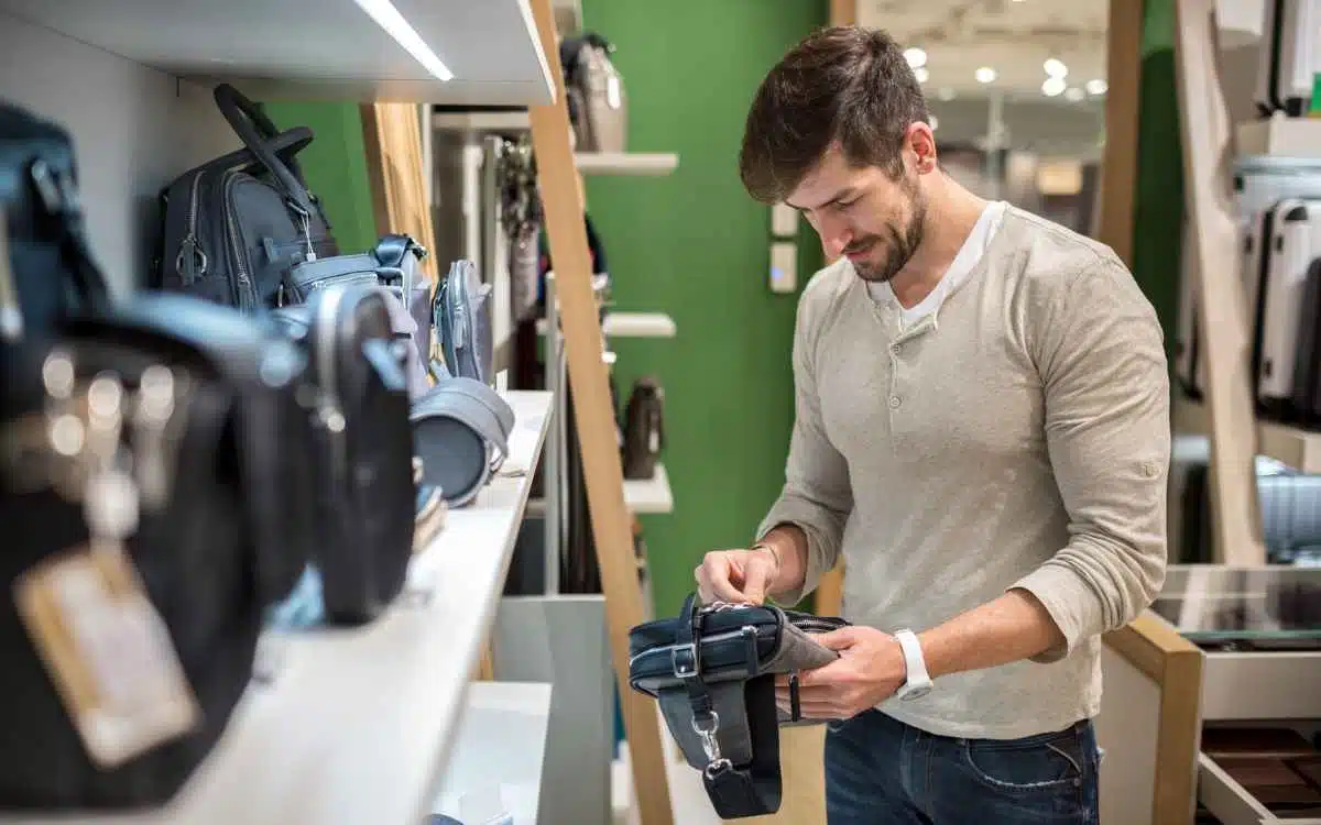 Vemos una imagen de un hombre comprando en una tienda de accesorios, en relación con los modelos de negocio a elegir cuando se investiga cómo emprender un negocio de accesorios.