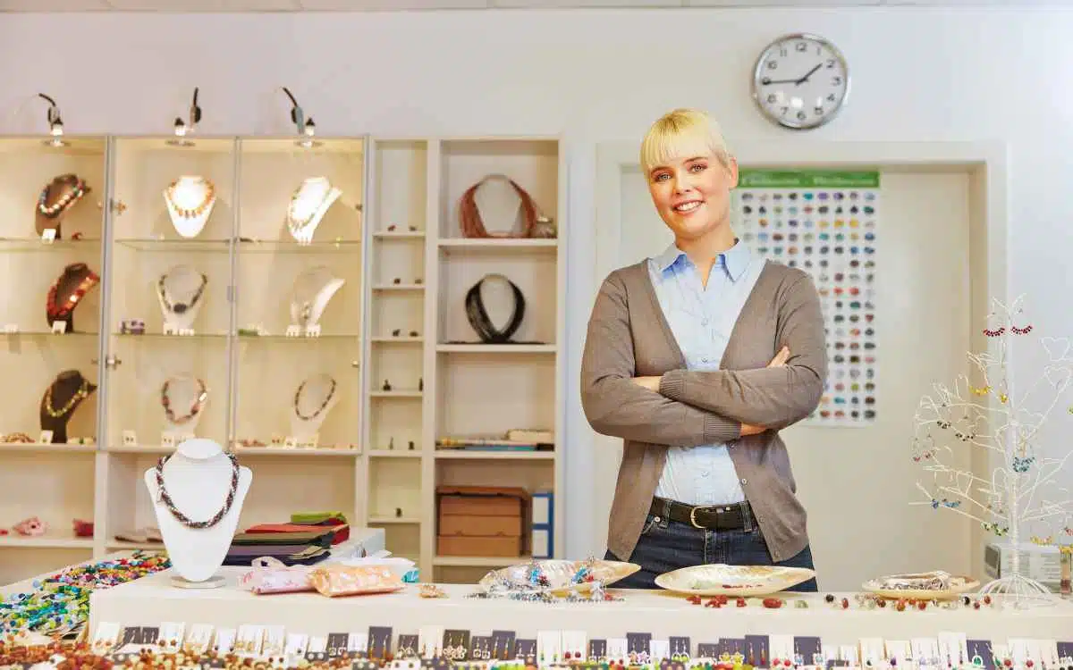 Vemos una imagen de una vendedora en una tienda de accesorios, en referencia a cómo emprender un negocio de accesorios.