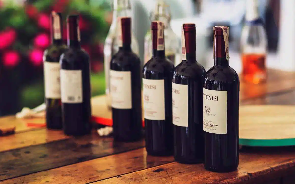 Vemos una fila de botellas de vino sobre una mesa, en relación con un estudio de mercado de vinos en el Perú.