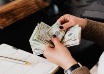 Vemos las manos de una persona contando dinero en referencia a negocios que dejan dinero diario (2)