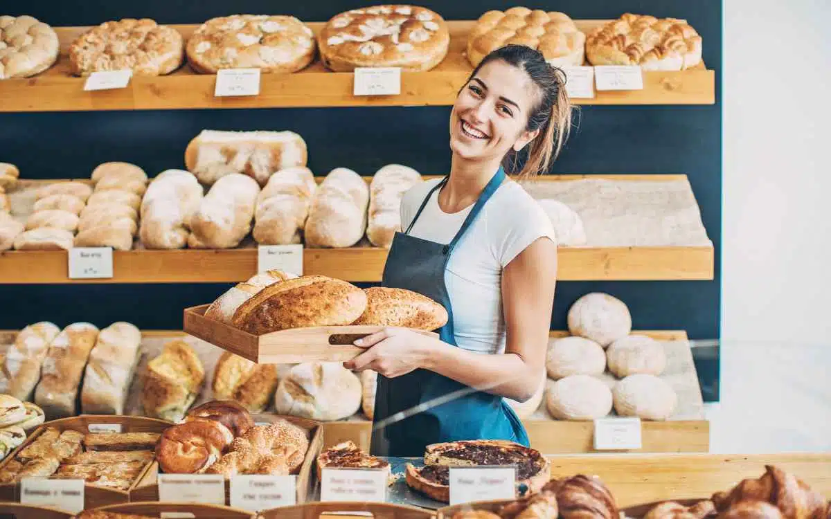 Vemos una imagen de una emprendedora en su panadería, en relación con el estudio de mercado de una panadería.