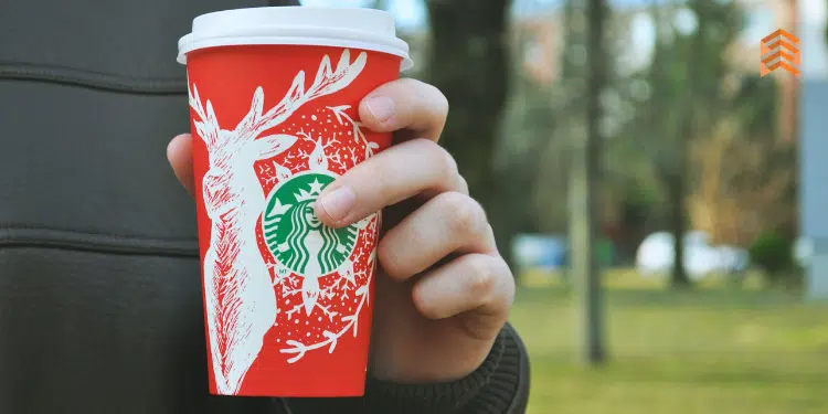 Vemos una imagen de una persona con un vaso de Starbucks, en relación con la misión y visión de Starbucks.