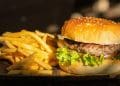Vemos una imagen de una hamburguesa con papas en un plato, en referencia a nombres para negocios de hamburguesas.