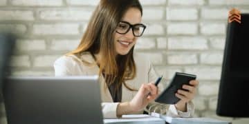 Vemos una persona usando una calculadora y sus computadoras en un curso de contabilidad.