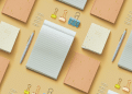Vemos una imagen de cuadernos de papel con otros accesorios de escritorio, en referencia a la búsqueda de nombres para papelerías.