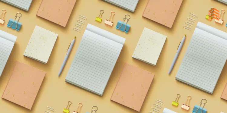 Vemos una imagen de cuadernos de papel con otros accesorios de escritorio, en referencia a la búsqueda de nombres para papelerías.