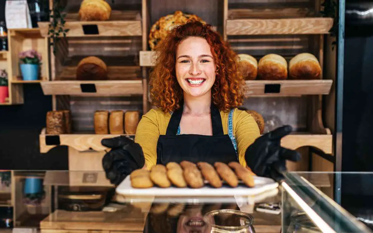 Vemos una imagen de una emprendedora ofreciendo los productos de su panadería.