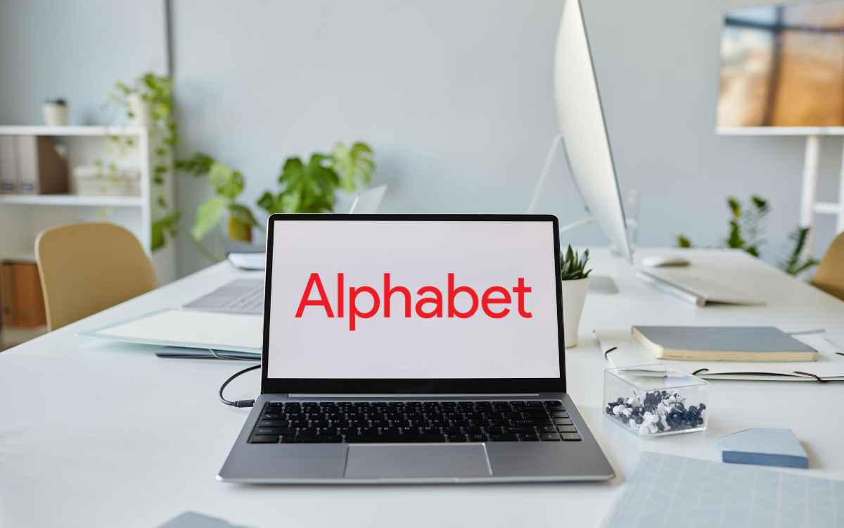 Vemos una imagen de una computadora en un escritorio de trabajo con la página de Alphabet, empresa matriz de Google.