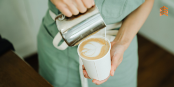 Vemos una barista preparando un café, en referencia a los nombres para cafeterías.