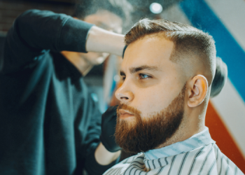 Vemos un barbero prestando servicios a un cliente, en relación con nombres de barberías.