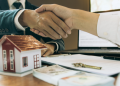 Vemos un agente inmobiliario cerrando una venta con un cliente, en relación con los nombres de inmobiliarias.