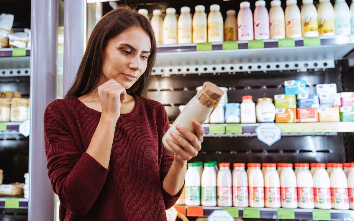 Vemos una mujer evaluando un producto lácteo, en relación con los diferentes motivos de compra, entre ellos, el precio.
