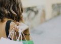 Vemos una imagen de una mujer con bolsas de shopping, en relación con los motivos de compra de los consumidores.