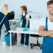 Vemos una imagen de tres personas realizando tareas de limpieza en una oficina, en relación con la búsqueda de nombres para empresas de limpieza.