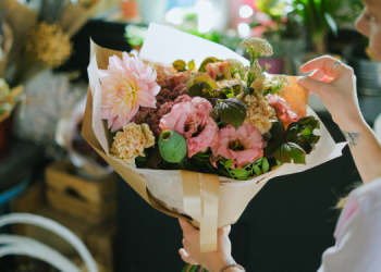 Vemos una persona creando un arreglo de flores, en relación con la búsqueda de nombres para florería.