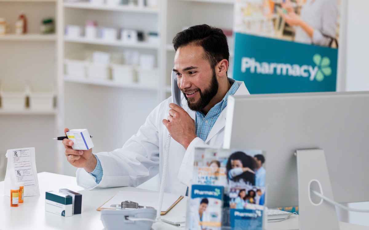 Vemos un farmacéutico atendiendo un pedido por teléfono, en relación con las estrategias para aumentar ventas en una farmacia.