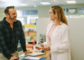 Vemos una farmacéutica atendiendo a un cliente en una farmacia.