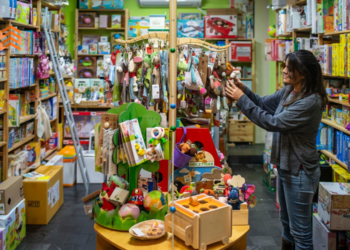 En la imagen se ve a una mujer en una tienda eligiendo regalos