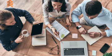 En la imagen se ven a 3 personas trabajando con sus computadoras