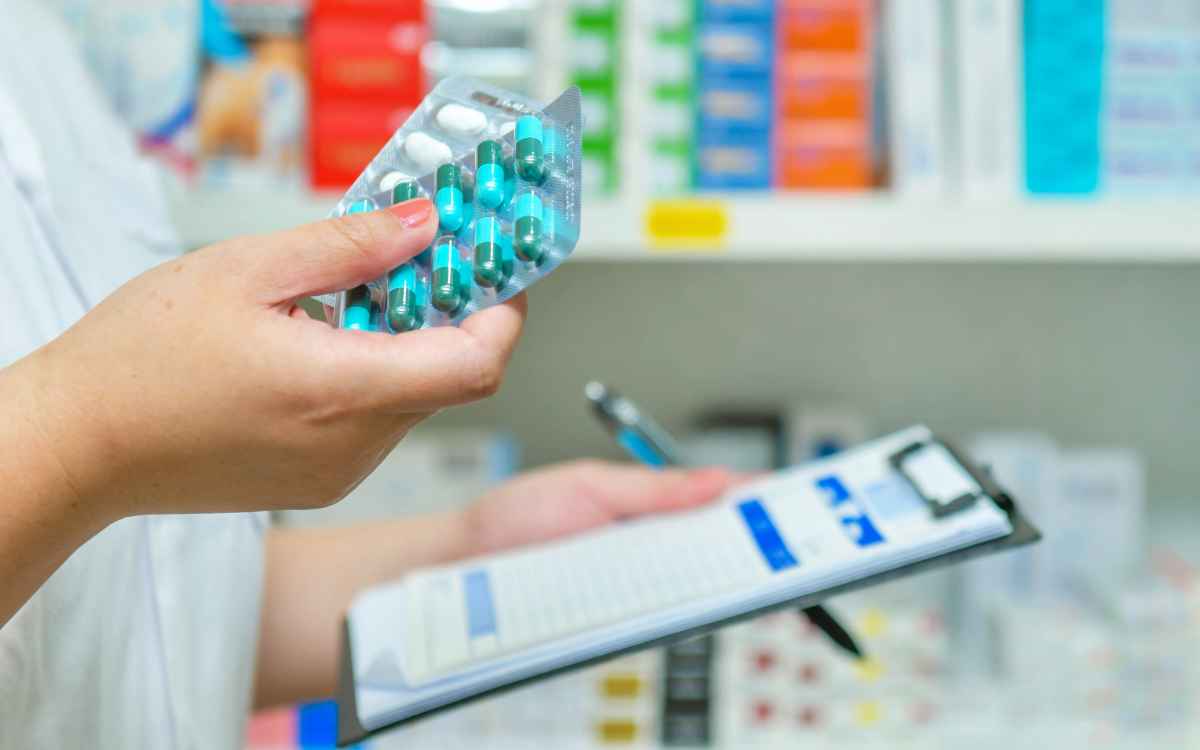 Vemos una persona realizando rotación de medicamentos, en relación con las estrategias para incrementar ventas en una farmacia.