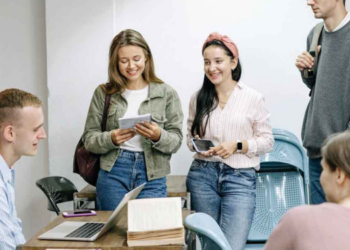 En la imagen se ve a un grupo de 5 jovenes conversando.