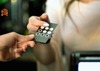 Vemos una persona entregando su tarjeta de cliente frecuente a un comerciante.