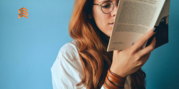 Libros de emprendimiento. En la imagen se ve a una chica con lentes leyendo un libro