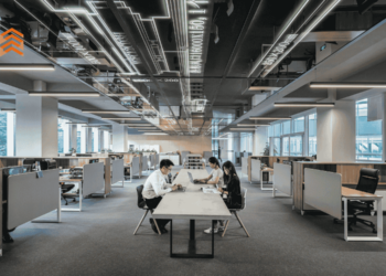 Grupo de tres personas trabajando reunido en una mesa larga