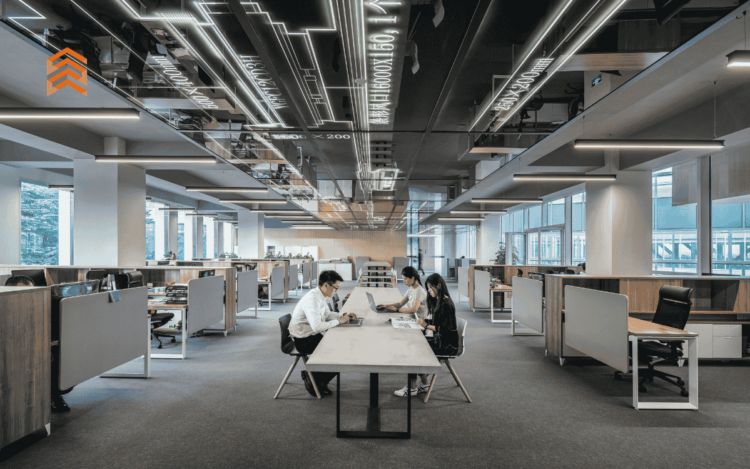 Grupo de tres personas trabajando reunido en una mesa larga